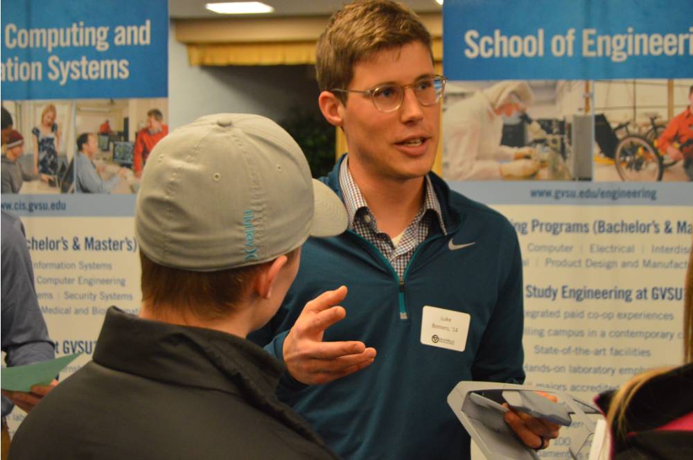 An alumnus talking to students about his field of study at the Academic Major Fair.